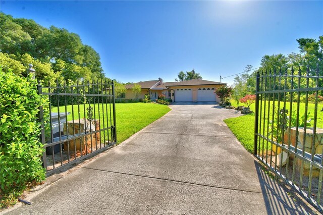 2611 State Road 557, Lake Alfred, FL 33850 - single story home with a front lawn, a gate, and driveway