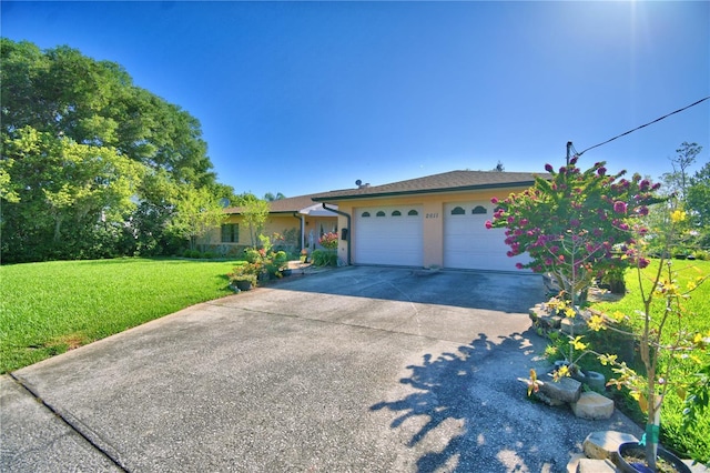 2611 State Road 557, Lake Alfred, FL 33850 - ranch-style house featuring a front yard, stucco siding, a garage, and concrete driveway