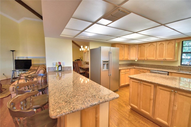 2611 State Road 557, Lake Alfred, FL 33850 - kitchen with appliances with stainless steel finishes, light stone counters, a peninsula, and light wood finished floors