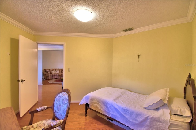 2611 State Road 557, Lake Alfred, FL 33850 - bedroom featuring a textured ceiling, wood finished floors, ornamental molding, and visible vents