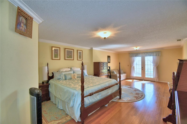 2611 State Road 557, Lake Alfred, FL 33850 - bedroom featuring crown molding, light wood-type flooring, a textured ceiling, access to exterior, and french doors