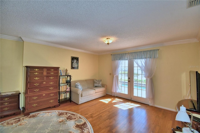 2611 State Road 557, Lake Alfred, FL 33850 - living area featuring visible vents, ornamental molding, a textured ceiling, wood finished floors, and french doors