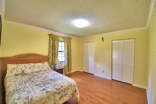 2611 State Road 557, Lake Alfred, FL 33850 - bedroom featuring a textured ceiling, wood finished floors, crown molding, and multiple closets