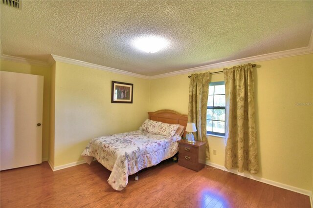 2611 State Road 557, Lake Alfred, FL 33850 - bedroom with visible vents, a textured ceiling, ornamental molding, and wood finished floors