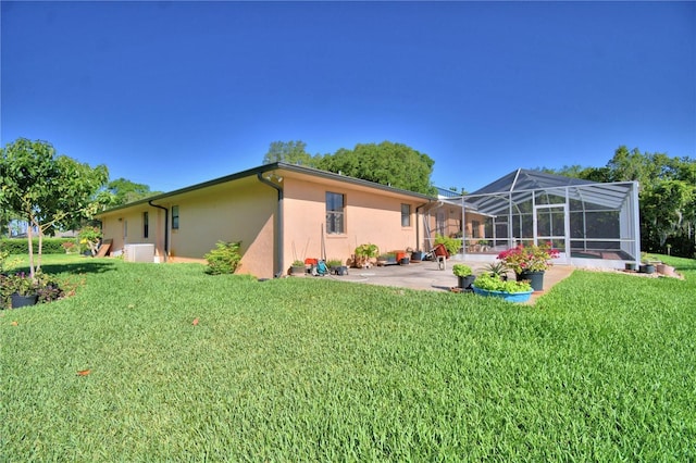 2611 State Road 557, Lake Alfred, FL 33850 - rear view of house with a lawn, a patio area, stucco siding, and glass enclosure