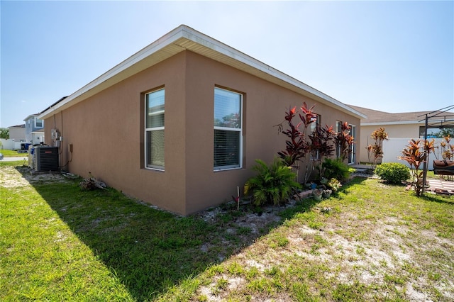 249 Haines Blvd, Winter Haven, FL 33881 - view of home's exterior featuring a yard, stucco siding, and central AC