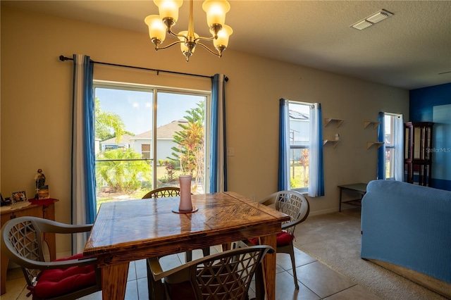 249 Haines Blvd, Winter Haven, FL 33881 - dining space with visible vents, a chandelier, a textured ceiling, light colored carpet, and light tile patterned flooring