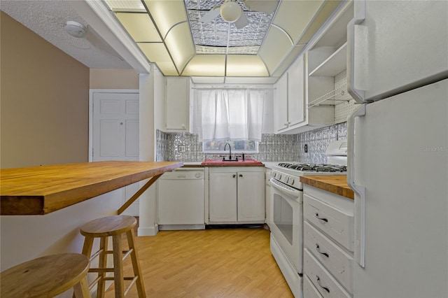 kitchen with butcher block countertops, light wood-type flooring, white appliances, open shelves, and a sink