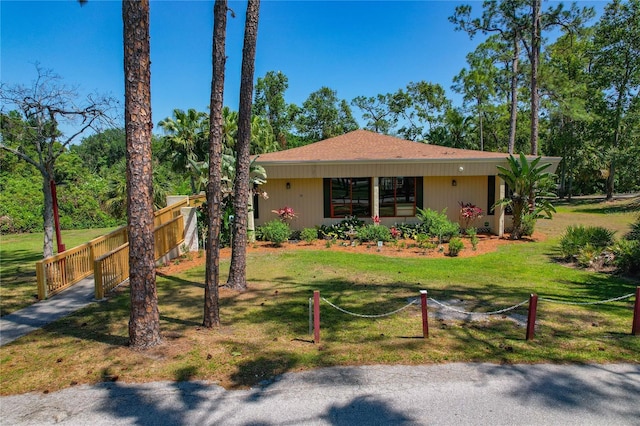 view of front of home with fence and a front lawn