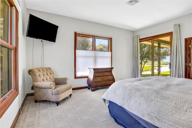bedroom featuring light carpet, visible vents, baseboards, and access to outside