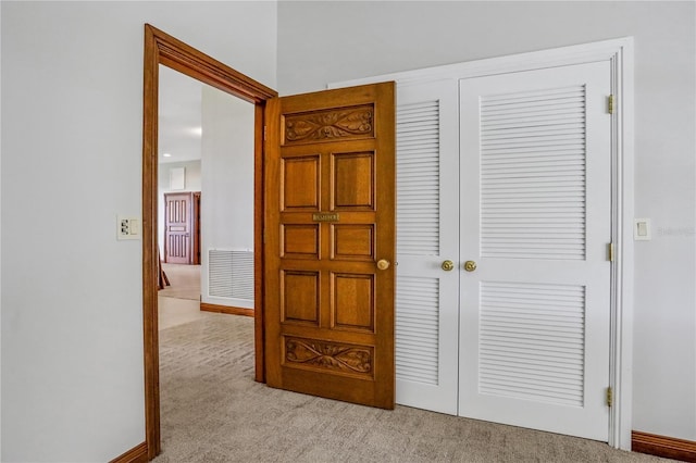 corridor with visible vents and light colored carpet