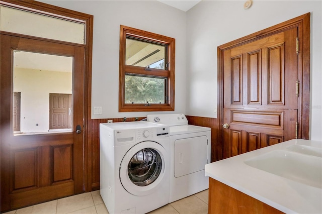 washroom with laundry area, washing machine and clothes dryer, wainscoting, and light tile patterned floors
