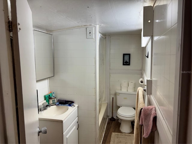 full bath featuring tile walls, wood finished floors, vanity, and toilet