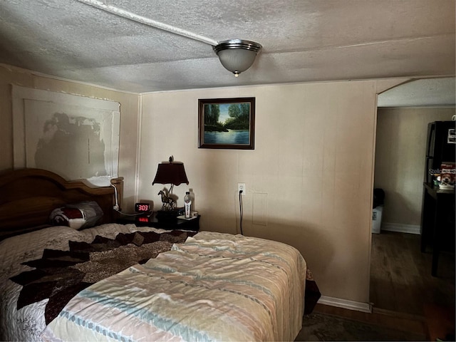 bedroom with wood finished floors and a textured ceiling