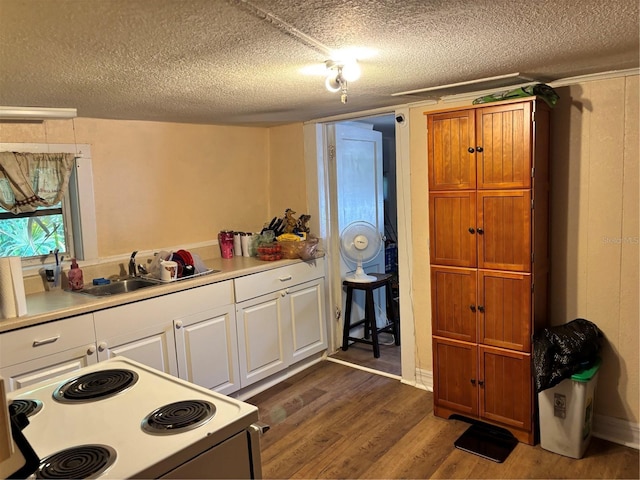 kitchen with dark wood-style floors, light countertops, a sink, white range with electric cooktop, and white cabinetry