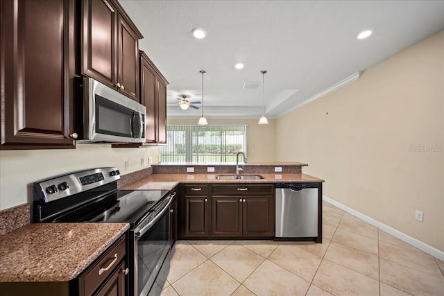 kitchen featuring a ceiling fan, dark brown cabinets, a sink, a peninsula, and appliances with stainless steel finishes