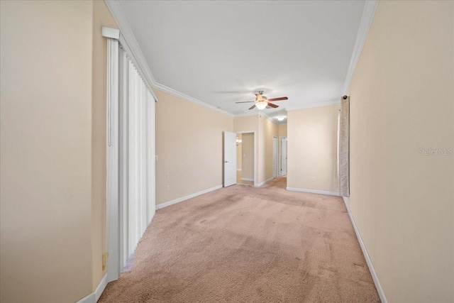 unfurnished room featuring light carpet, baseboards, ceiling fan, and crown molding