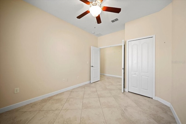 unfurnished bedroom featuring light tile patterned flooring, baseboards, visible vents, a closet, and ceiling fan