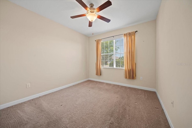 carpeted empty room with a ceiling fan and baseboards