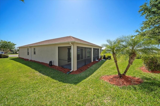 back of house with a lawn and stucco siding