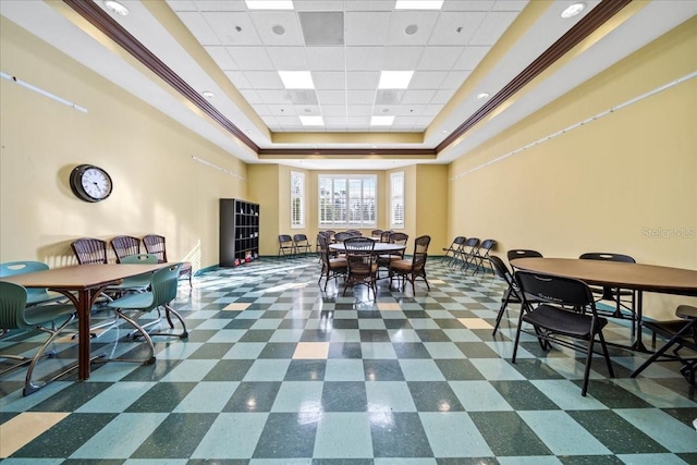 dining space with a tray ceiling and dark floors