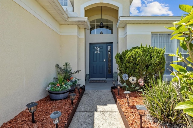 doorway to property featuring stucco siding