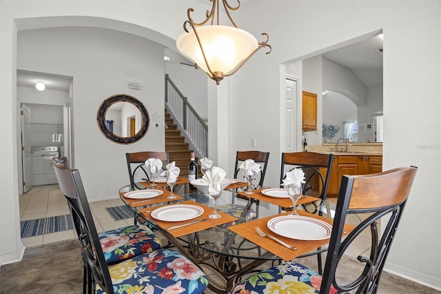 dining room with visible vents, stairway, arched walkways, and lofted ceiling