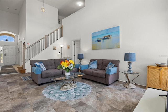 living area with a towering ceiling and stairs