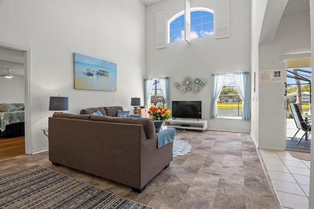 living room with baseboards and a towering ceiling
