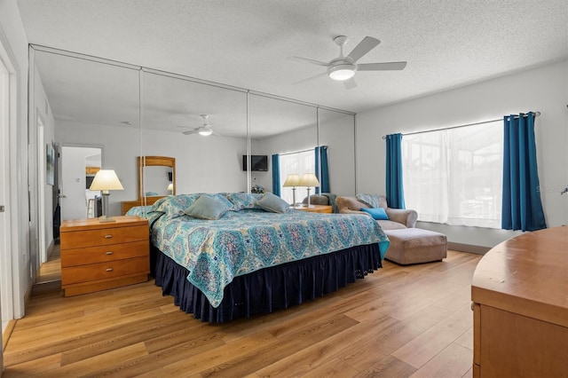 bedroom featuring light wood-type flooring, ceiling fan, and a textured ceiling