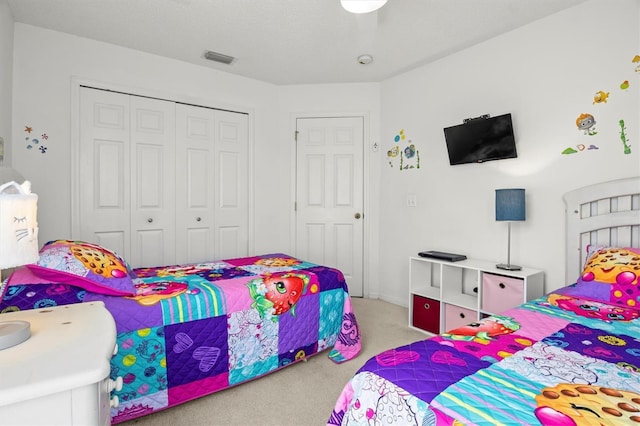 carpeted bedroom featuring a closet and visible vents
