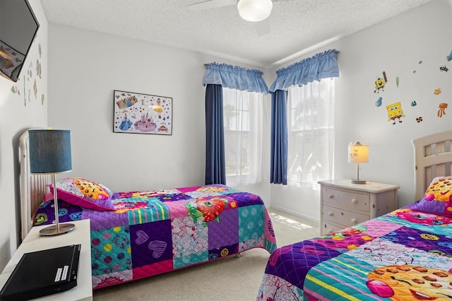 carpeted bedroom featuring a textured ceiling and a ceiling fan