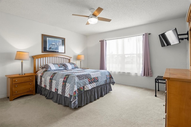 bedroom with ceiling fan, carpet flooring, baseboards, and a textured ceiling