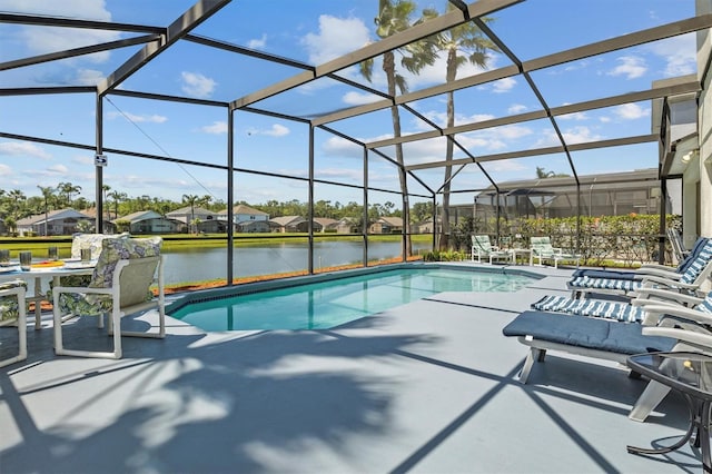 outdoor pool with a patio area, a residential view, a water view, and glass enclosure