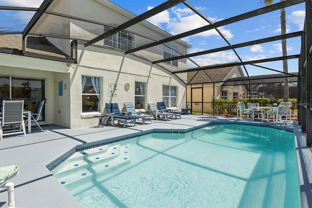 outdoor pool with glass enclosure and a patio