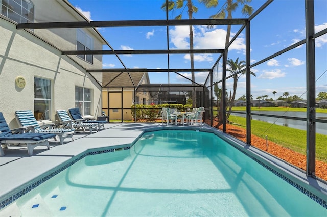outdoor pool with a water view, a patio area, and glass enclosure
