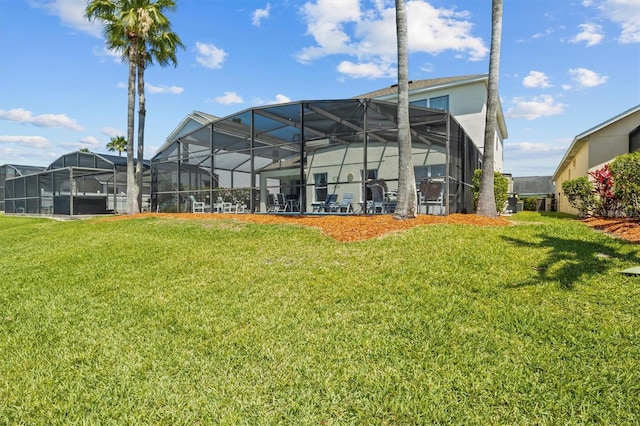 rear view of property featuring a lanai and a lawn
