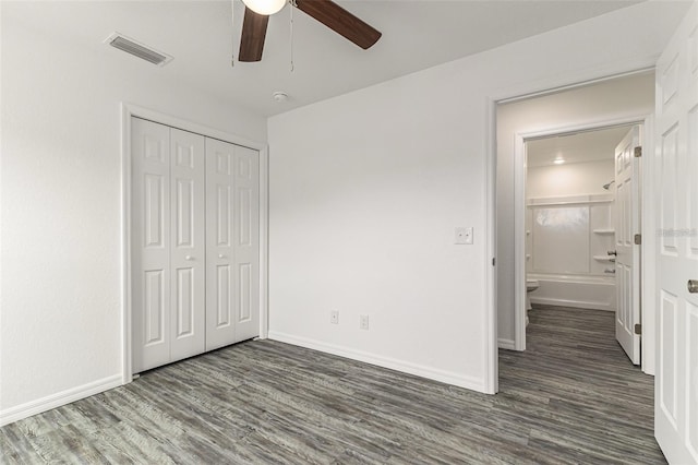 unfurnished bedroom with baseboards, wood finished floors, visible vents, and a closet