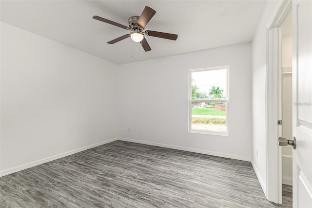 spare room featuring baseboards, a ceiling fan, and wood finished floors