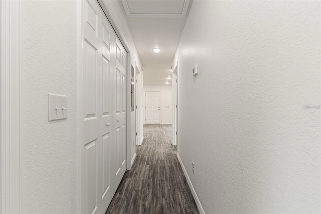 hall with recessed lighting, a textured wall, baseboards, and dark wood-style flooring