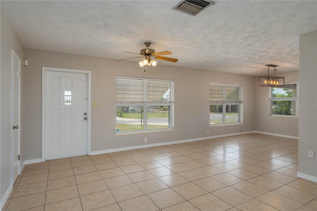 703 Osceola Ave, Lake Wales, FL 33853 - entrance foyer with a textured ceiling, baseboards, visible vents, ceiling fan with notable chandelier, and light tile patterned floors