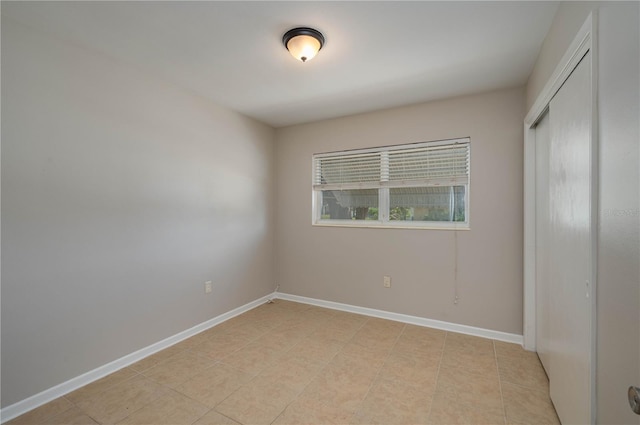 703 Osceola Ave, Lake Wales, FL 33853 - unfurnished bedroom with baseboards, a closet, and light tile patterned floors