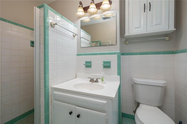 703 Osceola Ave, Lake Wales, FL 33853 - full bath with vanity, tile walls, a wainscoted wall, toilet, and visible vents