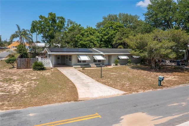 703 Osceola Ave, Lake Wales, FL 33853 - view of front of house featuring fence, a front lawn, driveway, and a carport
