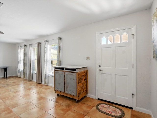foyer entrance with light tile patterned flooring and baseboards