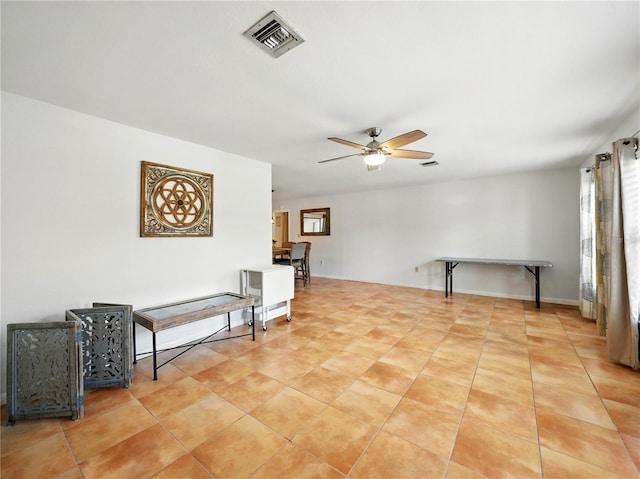 sitting room featuring ceiling fan, visible vents, and light tile patterned floors