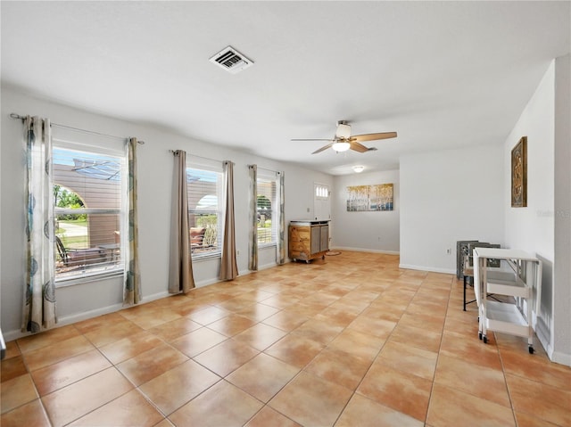 interior space featuring visible vents, a ceiling fan, baseboards, and light tile patterned floors