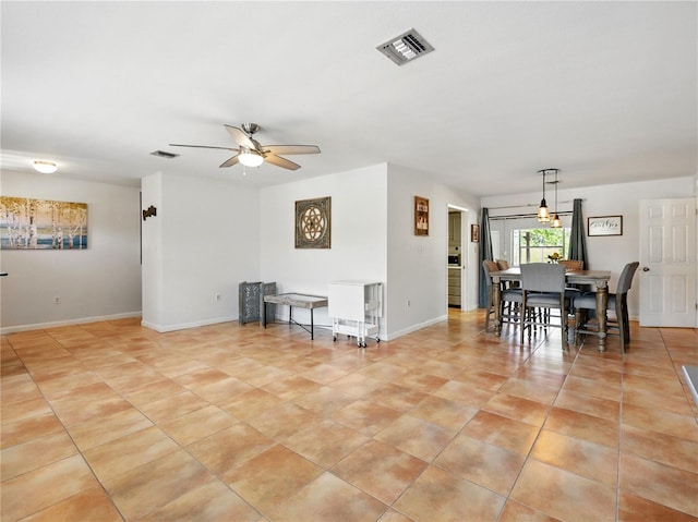 interior space with baseboards, a ceiling fan, visible vents, and light tile patterned floors