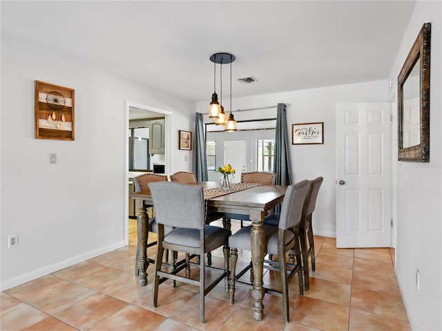 dining area with baseboards, visible vents, and light tile patterned floors