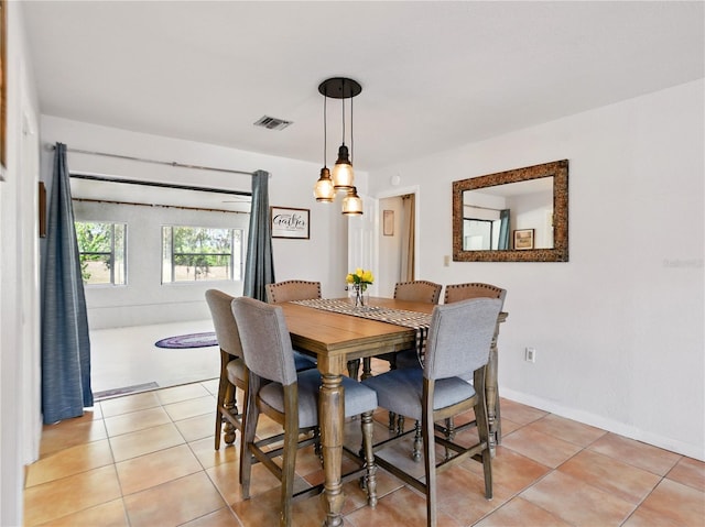 dining space featuring visible vents and light tile patterned floors